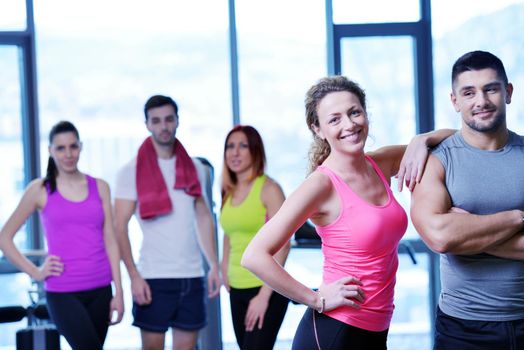 Group of people exercising at the gym and stretching