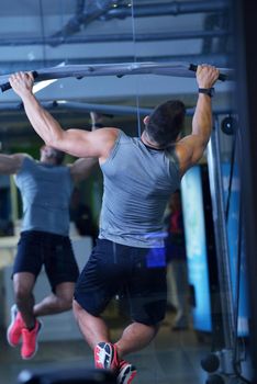 Strong handsome man exercising at the gym