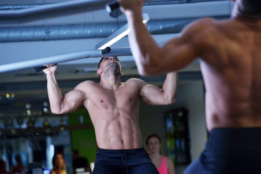 Strong handsome man exercising at the gym