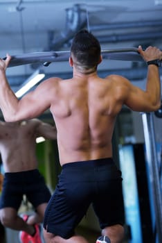 Strong handsome man exercising at the gym