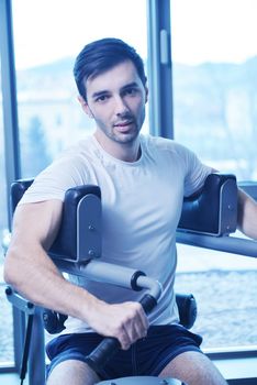 Handsome man running on the treadmill in modern gym