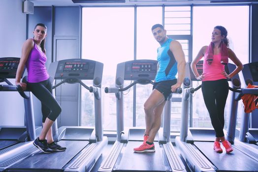 group of young people running on treadmills in modern sport  gym