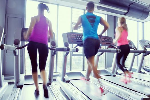 group of young people running on treadmills in modern sport  gym