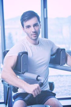 Handsome man running on the treadmill in modern gym