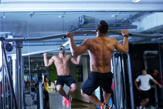 Strong handsome man exercising at the gym