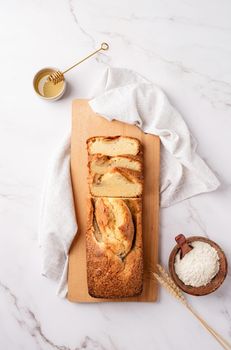 Baking and cooking. Top view of sliced banana bread on light concrete background with honey. Delicious sweet dessert or snack, morning breakfast