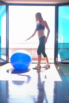 woman doing exercise with blue pilates ball