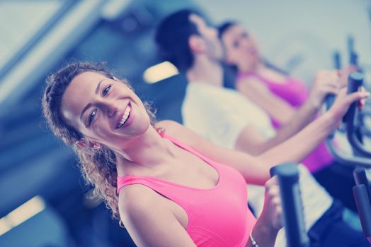 group of young people running on treadmills in modern sport  gym