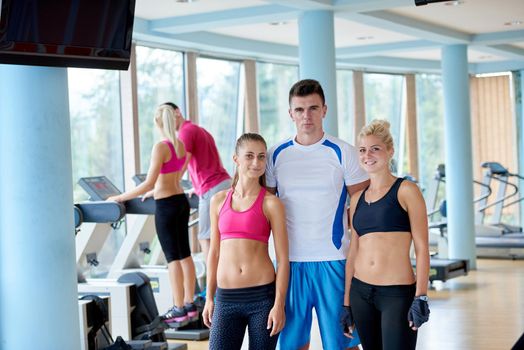 group portrait of healthy and fit young people in fitness gym