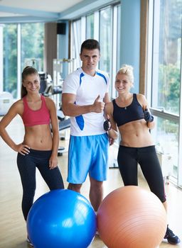 group portrait of healthy and fit young people in fitness gym