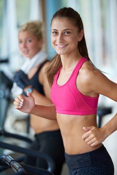 sport, fitness, lifestyle, technology and people concept - smiling woman exercising on treadmill in gym