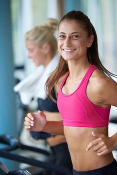 sport, fitness, lifestyle, technology and people concept - smiling woman exercising on treadmill in gym