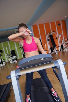 sport, fitness, lifestyle, technology and people concept - smiling woman exercising on treadmill in gym