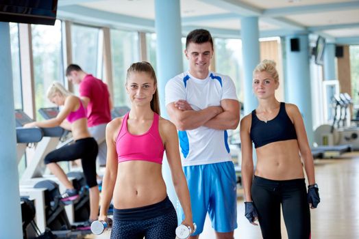 group portrait of healthy and fit young people in fitness gym