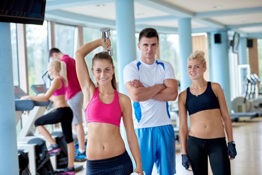 group portrait of healthy and fit young people in fitness gym