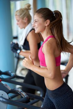 sport, fitness, lifestyle, technology and people concept - smiling woman exercising on treadmill in gym