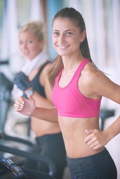 sport, fitness, lifestyle, technology and people concept - smiling woman exercising on treadmill in gym