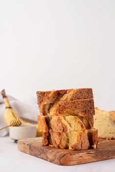 Baking and cooking. Front view of sliced banana bread on light concrete background with honey. Delicious sweet dessert or snack, morning breakfast. Copy space
