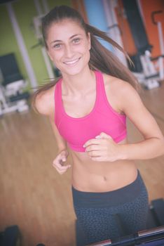 sport, fitness, lifestyle, technology and people concept - smiling woman exercising on treadmill in gym