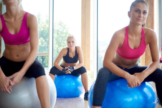 group of people exercise with balls on yoga class in fitness gym