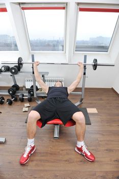 young man in fintess sport club exercise withweights and relaxing