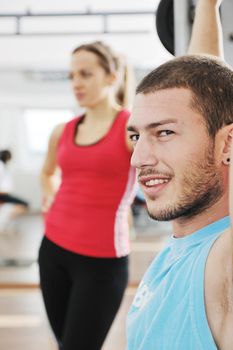 young man in fintess sport club exercise withweights and relaxing