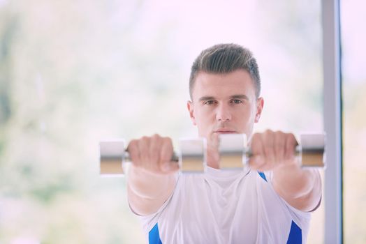 young man in fintess sport club exercise with weights and relaxing