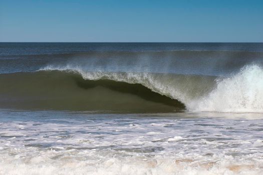 Breaking wave at Nags Head, North Carolina beach curls over.