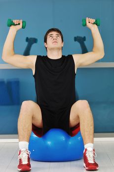 young man in fintess sport club exercise withweights and relaxing