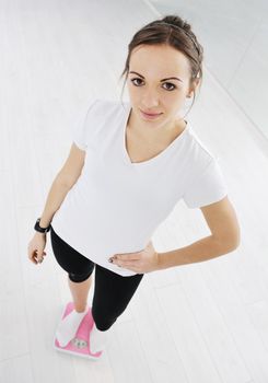 happy diet concept with young woman on pink scale at sport fitnes gym club