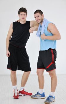 two young adults exercise fitness jumping and relaxing at sport gym club