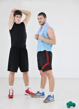 two young adults exercise fitness jumping and relaxing at sport gym club