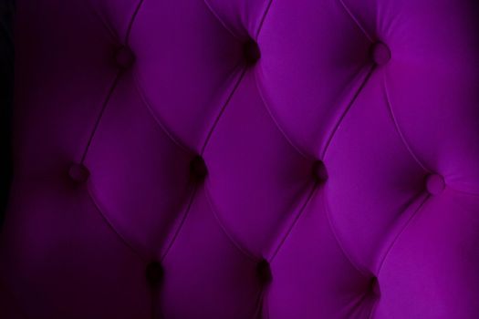 Lilac velour background with quilted upholstery in the style of Chesterfield close-up.