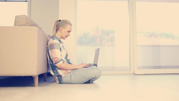 beautiful young women using laptop computer on the floor of her luxury home