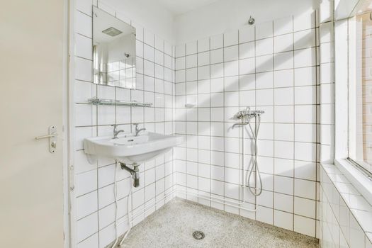 Bathroom with white tiles and a window to the street
