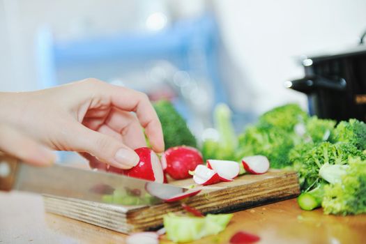 woman preparing healthy food salad with green and red vegetable and knife