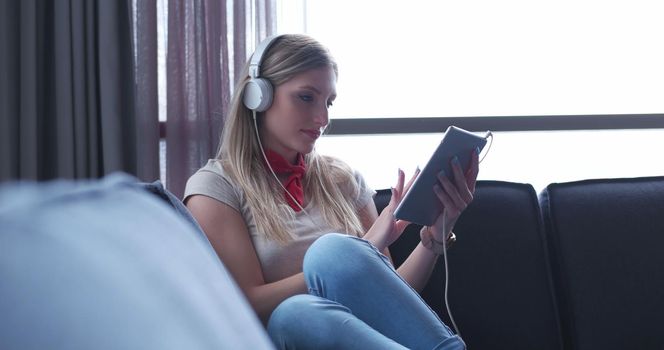 woman listening to music with sun flare coming from window of apartment