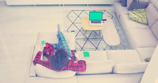 Young couple on the sofa watching television together in their luxury home