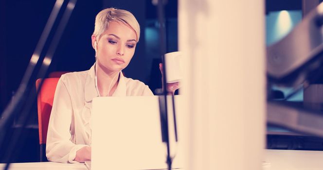 young female entrepreneur working on laptop computer in night office