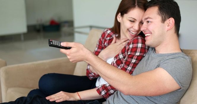 Young couple watching tv in the living roonm