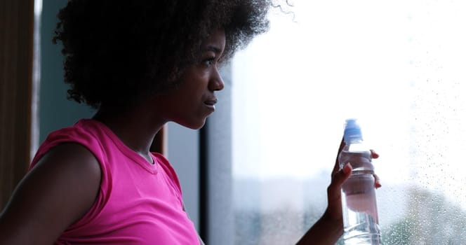 young Athletic healthy black woman resting during workout in gym