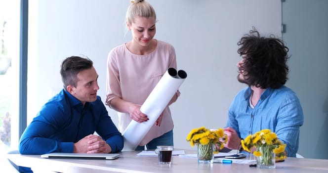 Group of a young business people discussing business plan at modern startup office building