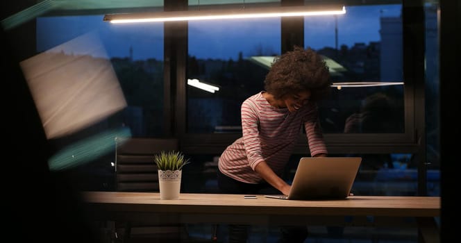 Young african american female Entrepreneur Freelancer Working Using A Laptop In night Coworking space