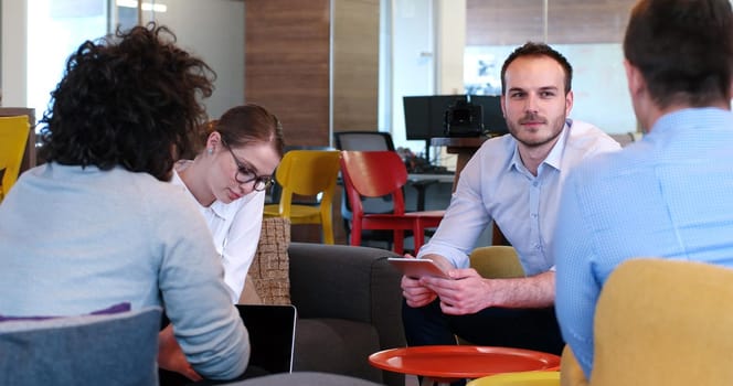 Group of a young business people discussing business plan at modern startup office building