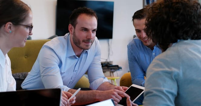 Group of a young business people discussing business plan at modern startup office building