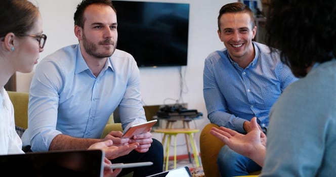 Group of a young business people discussing business plan at modern startup office building