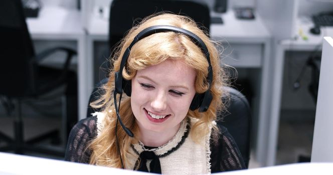 young smiling female call centre operator doing her job with a headset