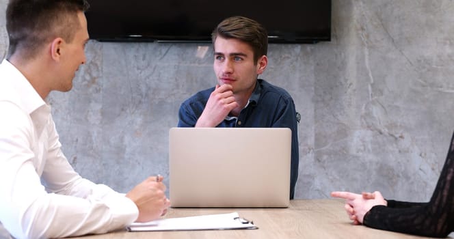 Group of a young business people discussing business plan at modern startup office building