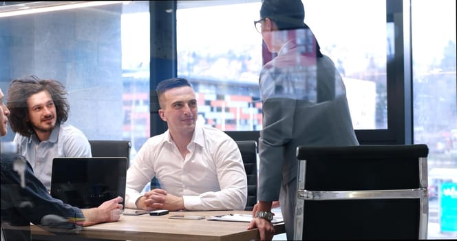 Group of a young business people discussing business plan at modern startup office building