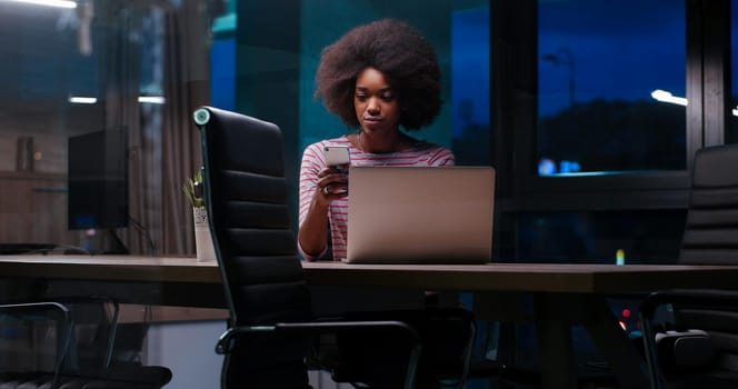 Young african american female Entrepreneur Freelancer Working Using A Laptop In night Coworking space